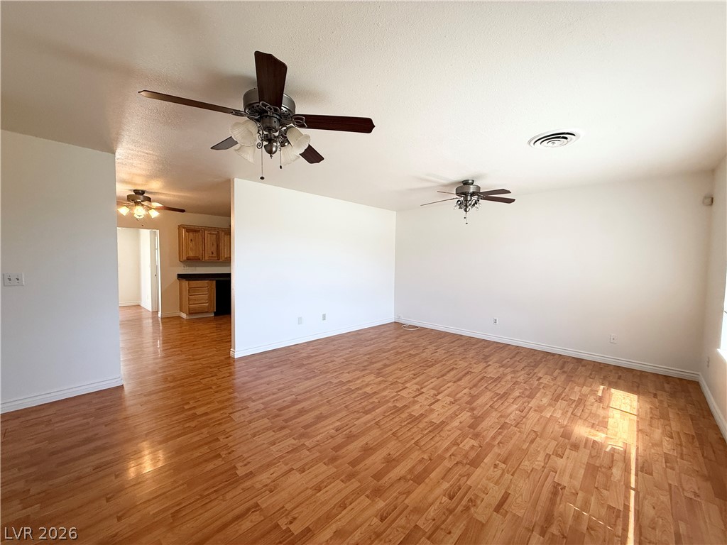 616 Greenway Road Henderson, NV 89002 - Photo 2 of 32 Laminate flooring connects a bright open-concept living space to a functional kitchen area.
