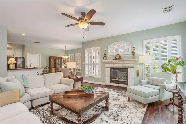 a living room with furniture a fireplace and wooden floor