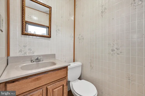 a bathroom with a sink a toilet and a mirror