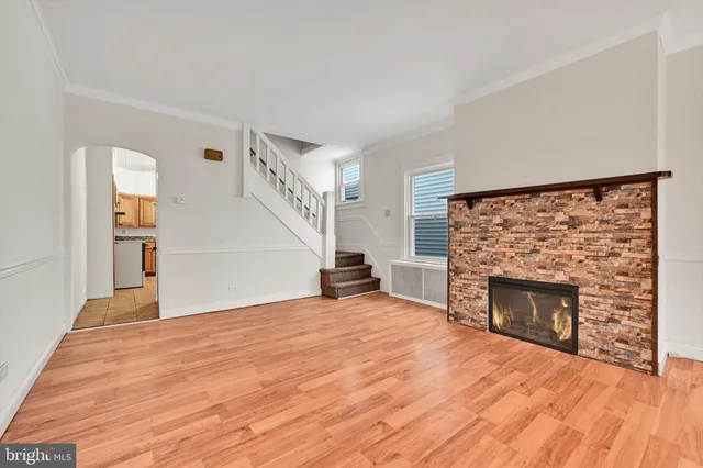 a view of empty room with wooden floor and fireplace