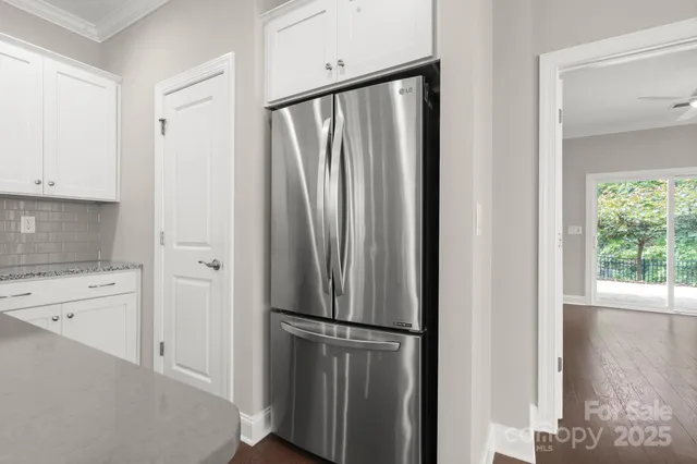a view of a kitchen with white cabinets and wooden floor