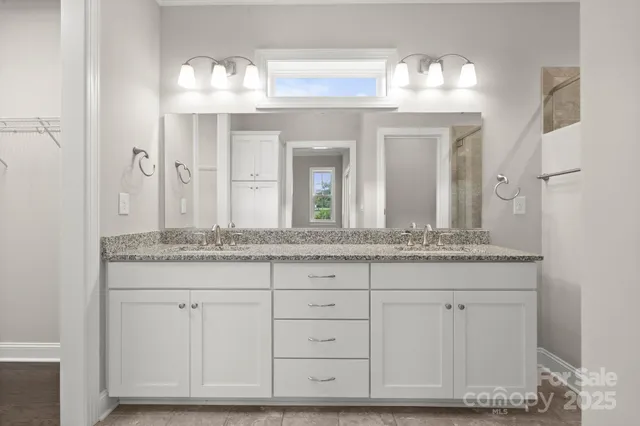 a bathroom with a granite countertop sink two mirror and a