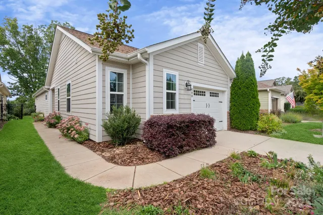 a view of a house with a small yard and a garden