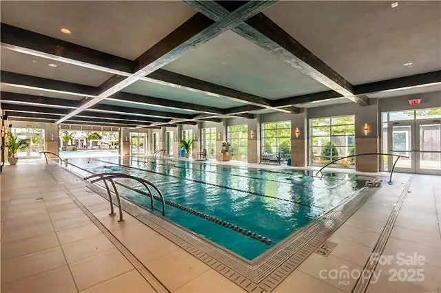 a swimming pool with large glass windows and painted walls