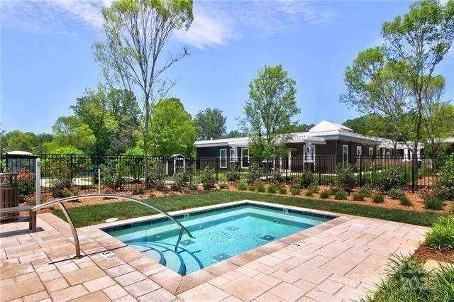a view of a swimming pool with lawn chairs under an umbrella