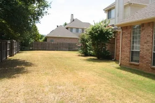 a view of an house with backyard and trees