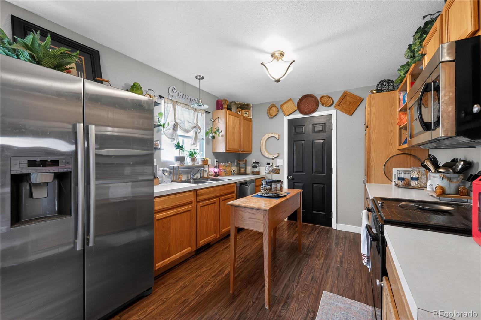3170 West 3rd Street Road Greeley, CO 80631 - Photo 12 of 29 a kitchen with stainless steel appliances granite countertop a refrigerator a stove and a sink with wooden floor