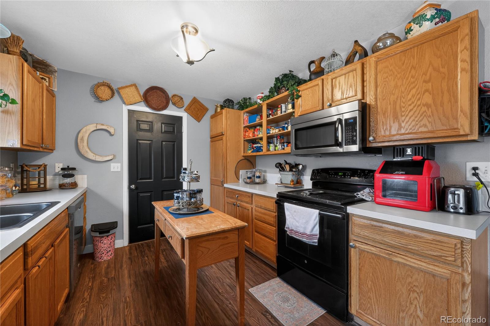 3170 West 3rd Street Road Greeley, CO 80631 - Photo 16 of 29 a kitchen with stainless steel appliances granite countertop a stove top oven a sink dishwasher and cabinets with wooden floor