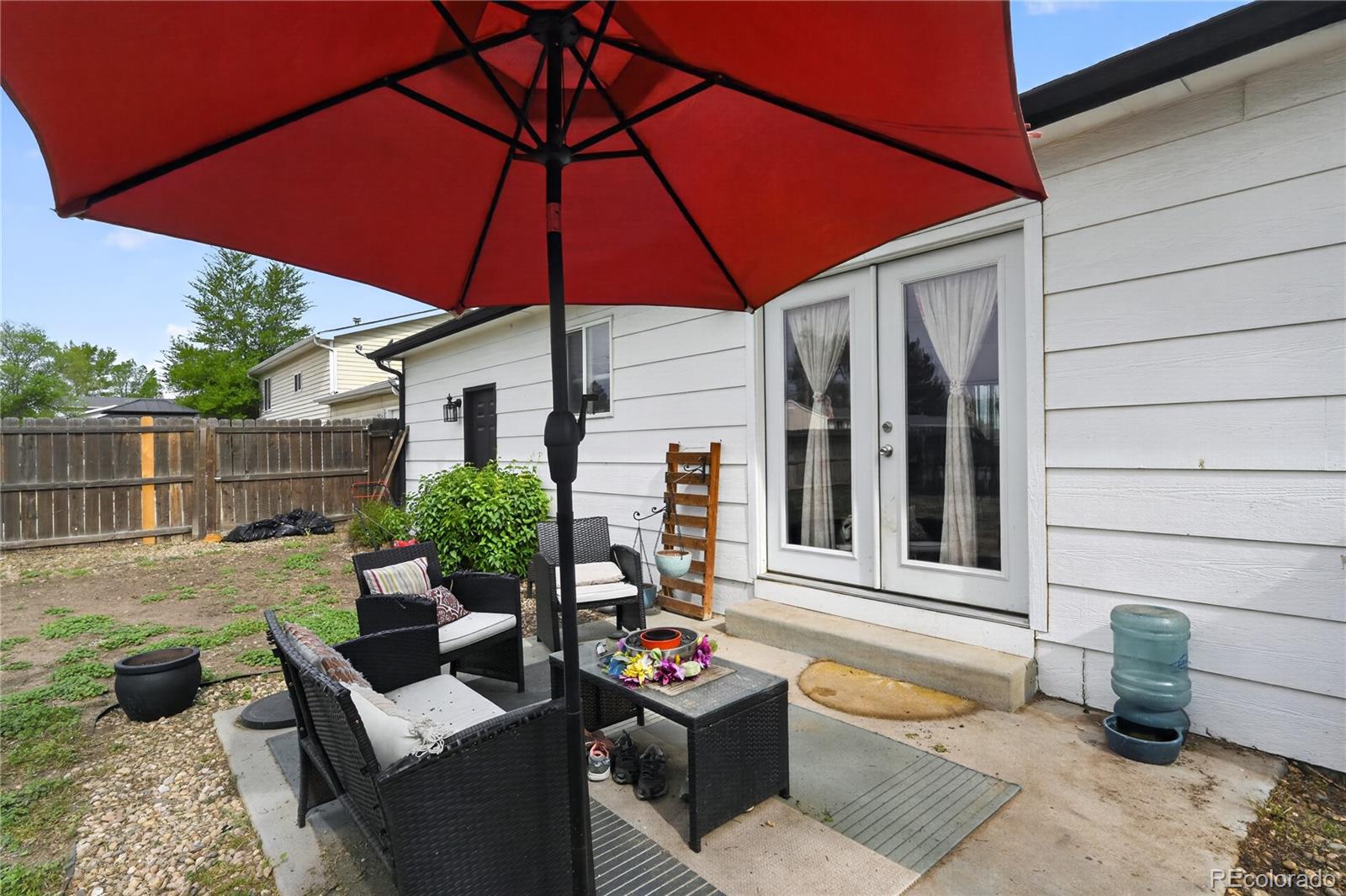 3170 West 3rd Street Road Greeley, CO 80631 - Photo 25 of 29 a view of a patio with couches table and chairs under an umbrella