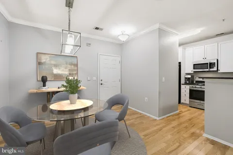 a kitchen with stainless steel appliances a dining table and chairs