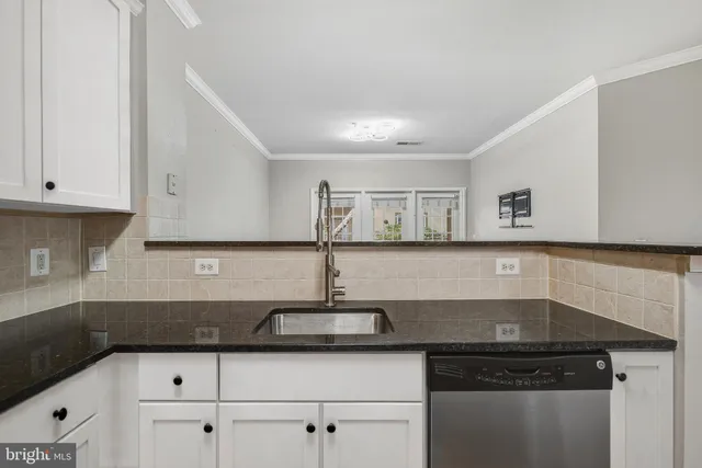 a kitchen with granite countertop a sink and cabinets