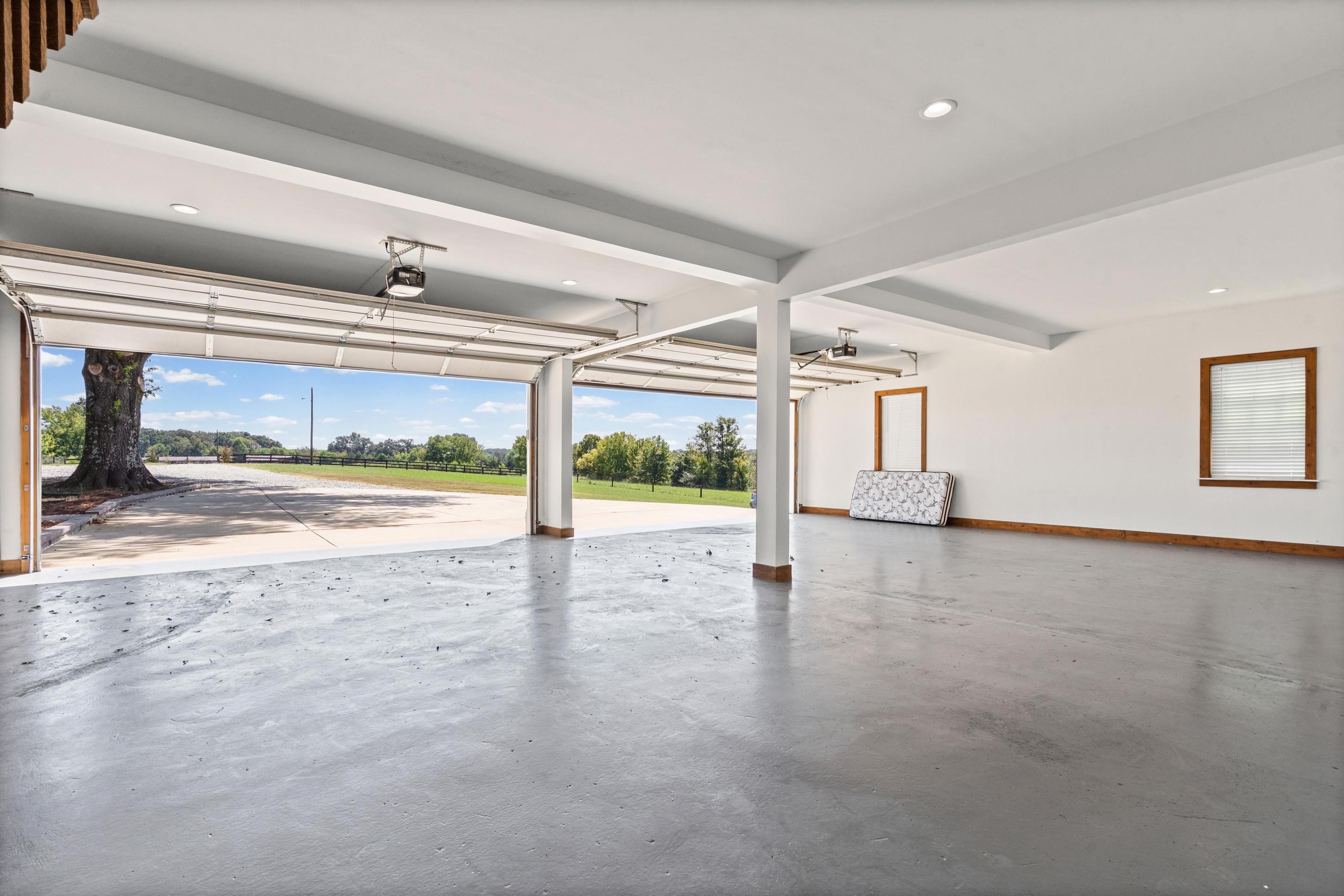 620 Diffee Road Moscow, TN 38057 - Photo 18 of 25 Two overhead garage doors, recessed ceiling lighting, structural support columns, and an epoxy concrete floor, huge four car garage