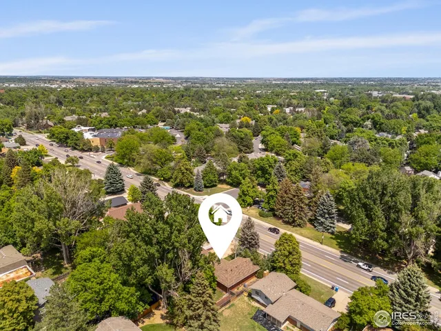 a view of a lush green field with lots of trees in the background