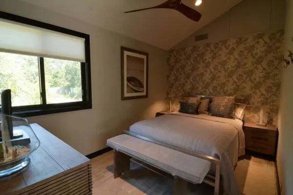 a bedroom with a bed and a flat tv screen on dresser