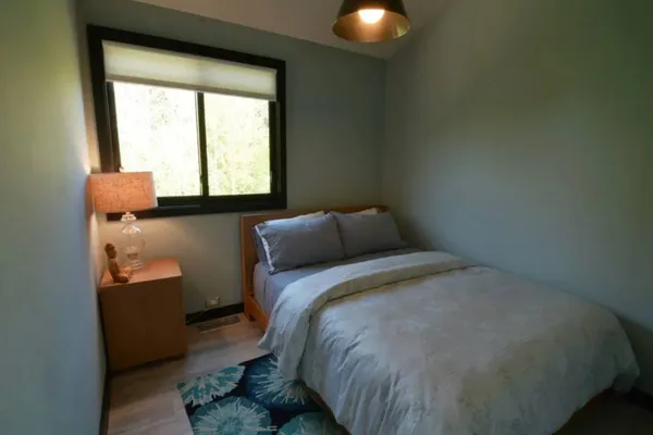 a bed sitting in a bedroom next to a window