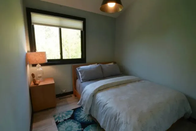 a bed sitting in a bedroom next to a window