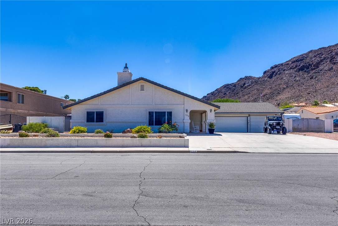 524 Swallow Cove Boulder City, NV 89005 - Photo 57 of 58 A desert oasis with mountain vistas awaits, featuring a welcoming facade and convenient attached garage.