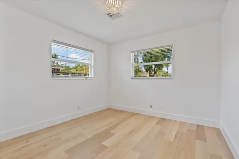 a view of an empty room with a window and a ceiling fan