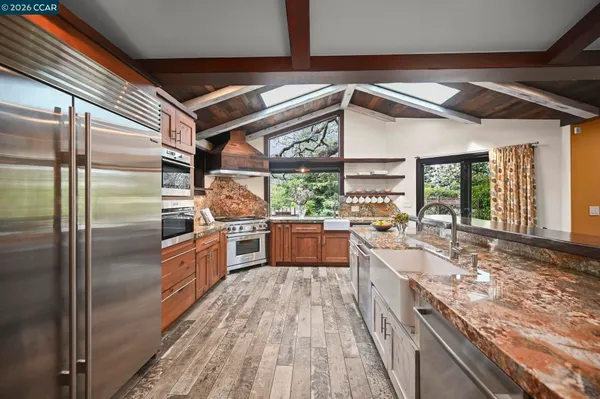 a patio with wooden floor a yard a table and chairs