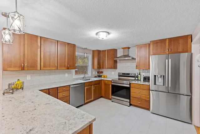a kitchen with granite countertop stainless steel appliances a refrigerator sink and microwave