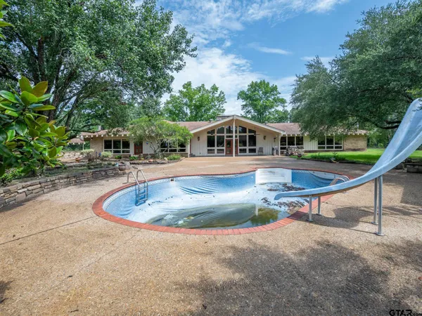 a swimming pool with outdoor seating and yard