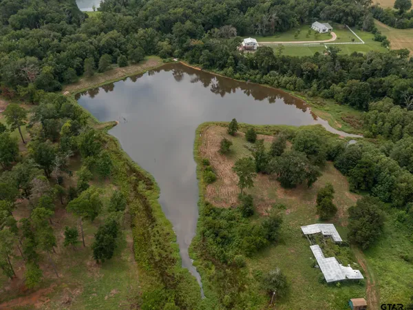 an aerial view of lake residential house with outdoor space and trees around