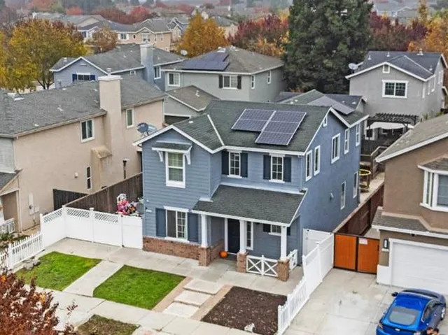a front view of a house with a garden and trees
