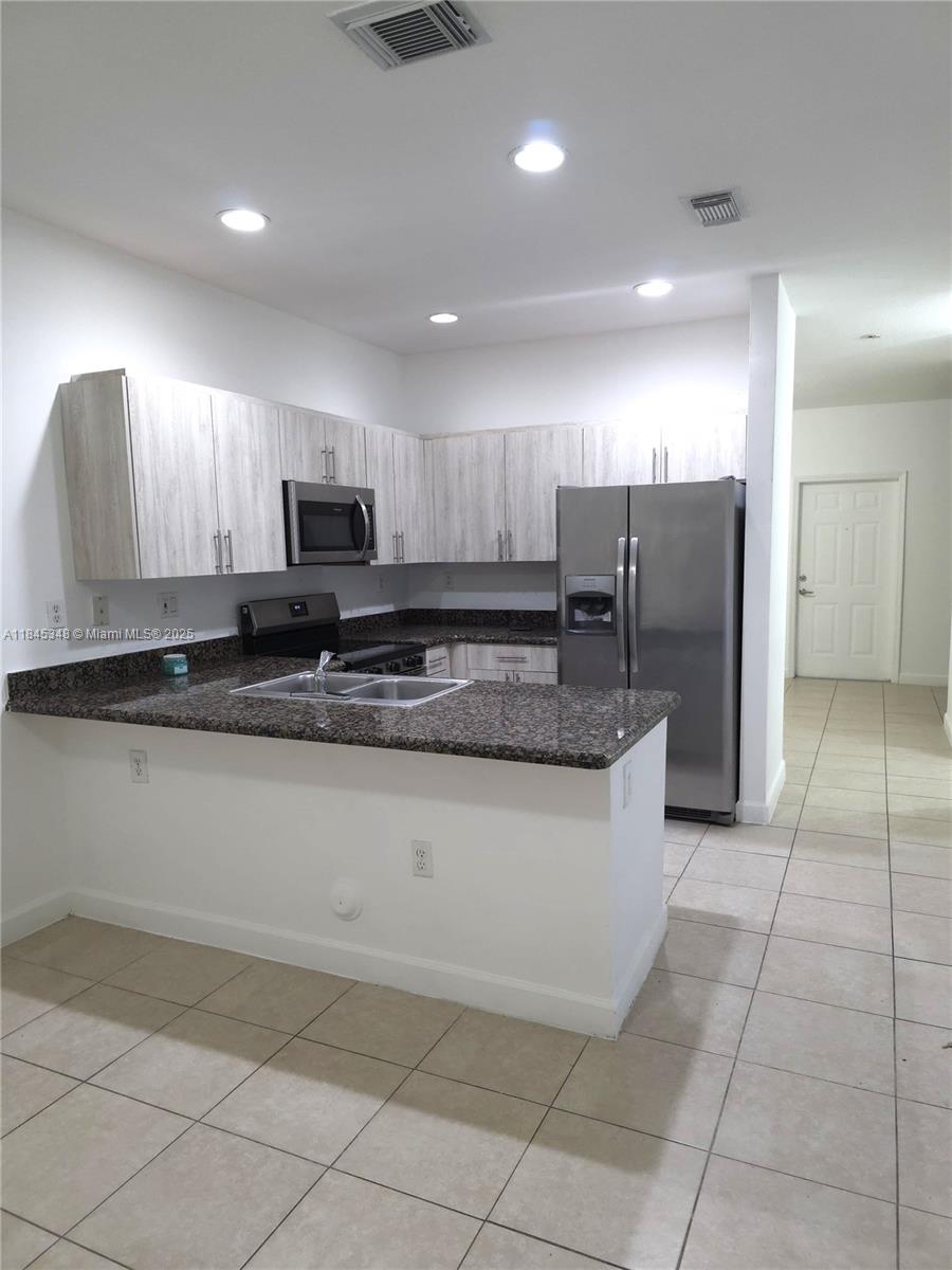 11357 Southwest 230th Terrace Miami, FL 33170 - Photo 6 of 24 a large kitchen with stainless steel appliances a stove a sink a refrigerator and a microwave
