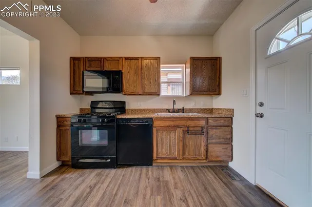 a kitchen with granite countertop a stove top oven and sink