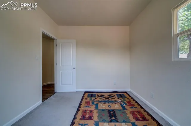 a bedroom with wooden floor and window