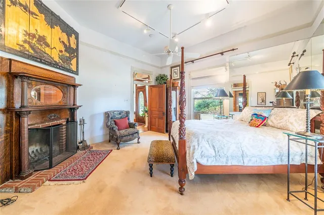 a bedroom with a bed couch and a large window with the garden view