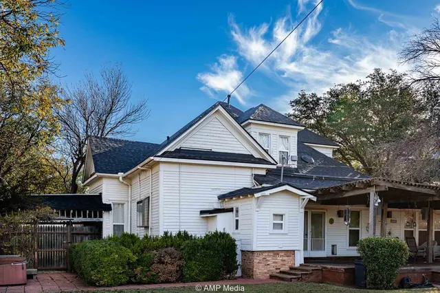 a view of a white house next to a yard