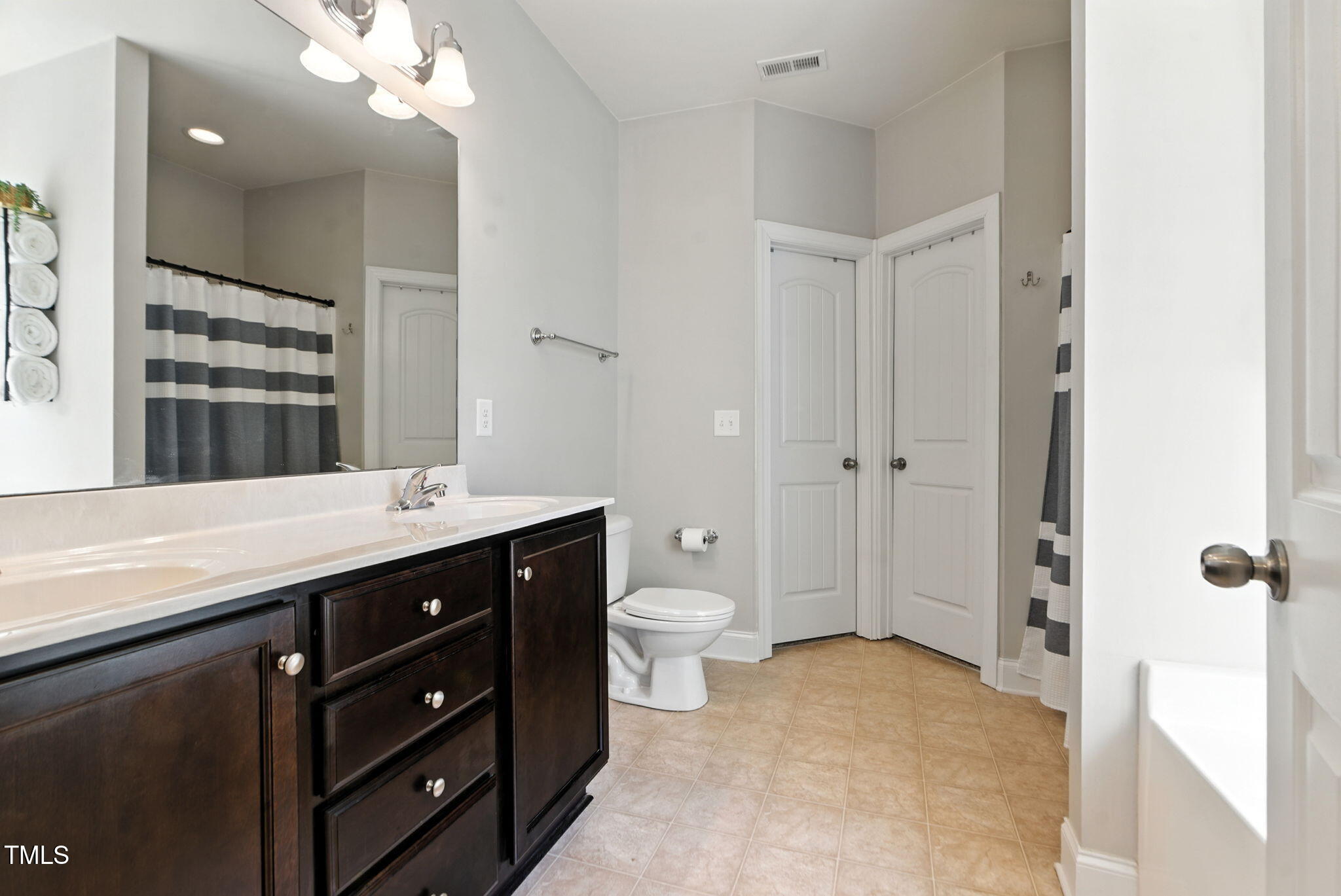311 Coachmans Trail Stem, NC 27581 - Photo 14 of 27 a bathroom with a double vanity sink toilet and shower