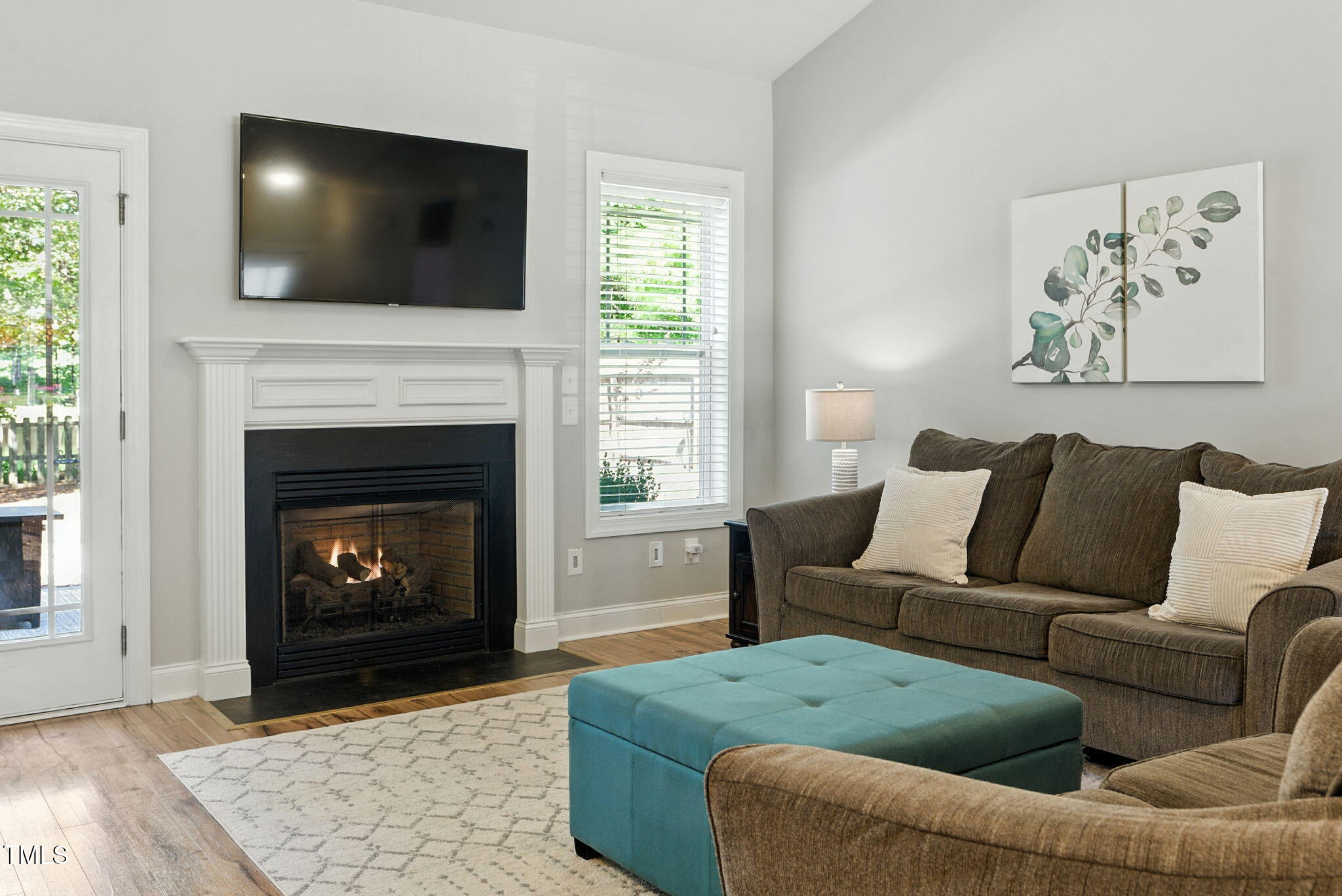 311 Coachmans Trail Stem, NC 27581 - Photo 6 of 27 a living room with furniture a flat screen tv and a fireplace