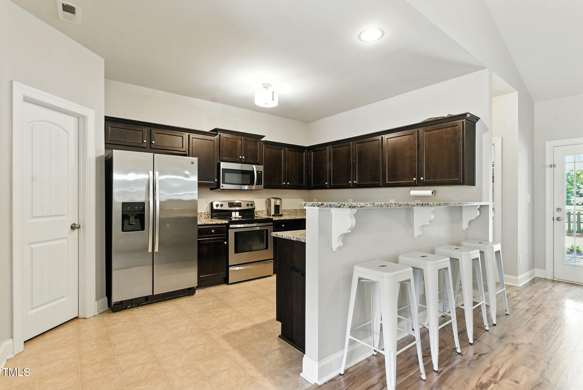 311 Coachmans Trail Stem, NC 27581 - Photo 9 of 27 a kitchen with stainless steel appliances granite countertop a refrigerator stove microwave and sink