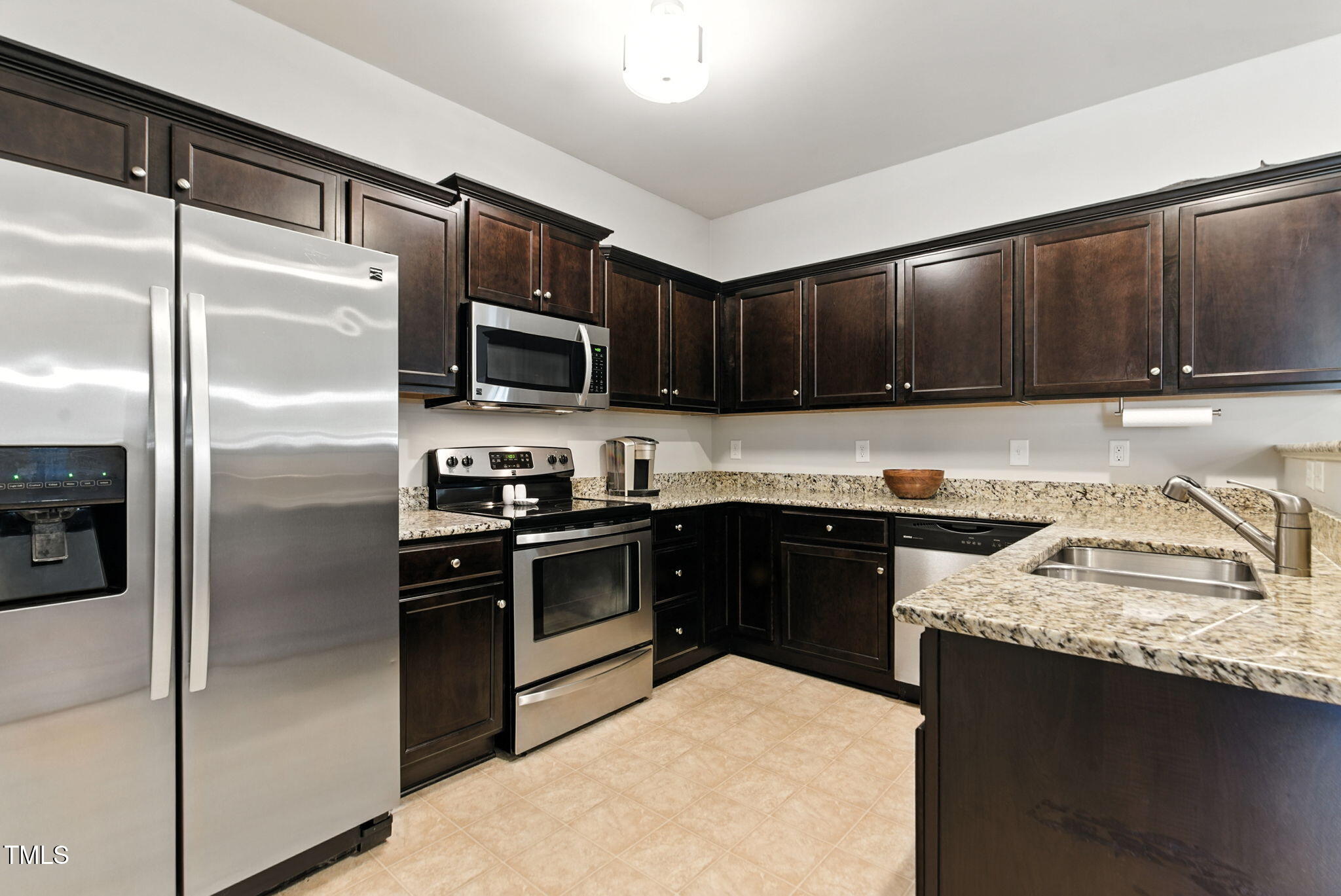 311 Coachmans Trail Stem, NC 27581 - Photo 10 of 27 a kitchen with granite countertop stainless steel appliances and wooden cabinets