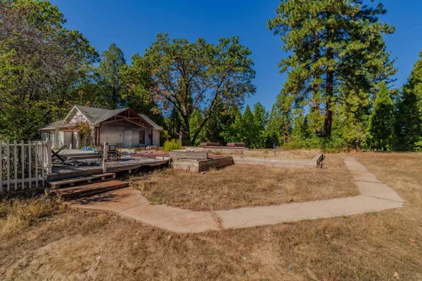 a backyard of a house with wooden floor and trees