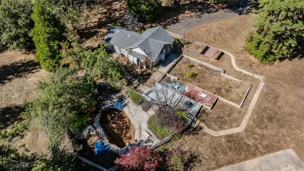 an aerial view of a house with a yard and street view