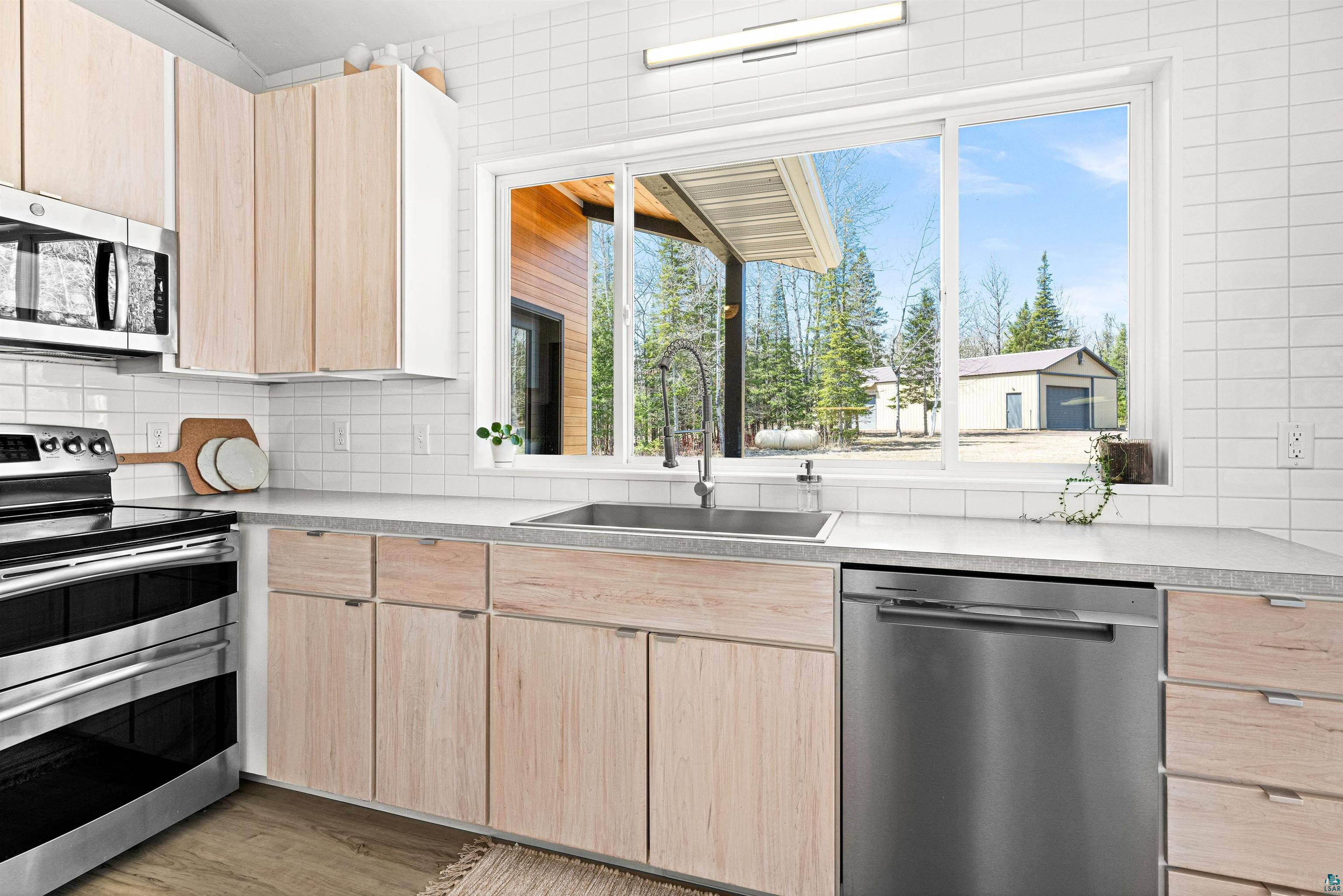 5638 Bergquist Road Duluth, MN 55804 - Photo 12 of 43 Kitchen featuring a wealth of natural light, light brown cabinets, appliances with stainless steel finishes, and a sink