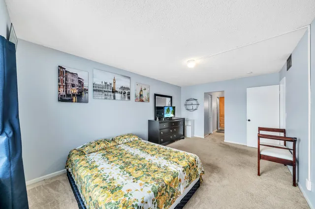 a bedroom with a bed and a dresser in it