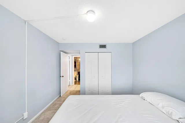 a bedroom with a bed wall painting and a window