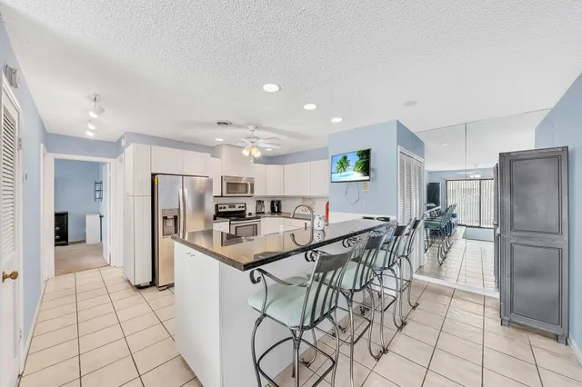 a kitchen with granite countertop a sink and white cabinets