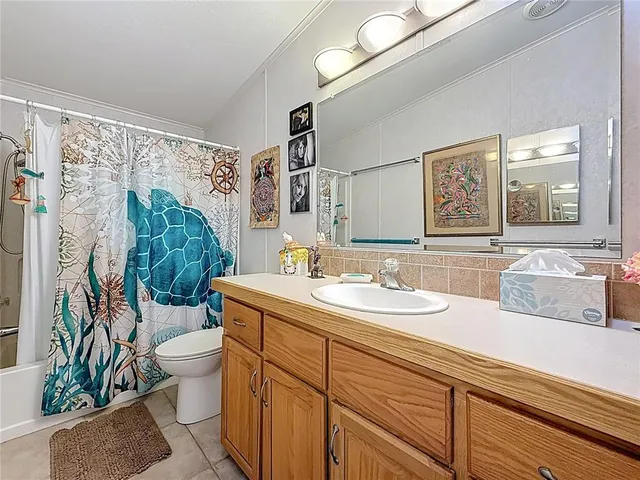 a bathroom with a granite countertop sink a toilet and a mirror