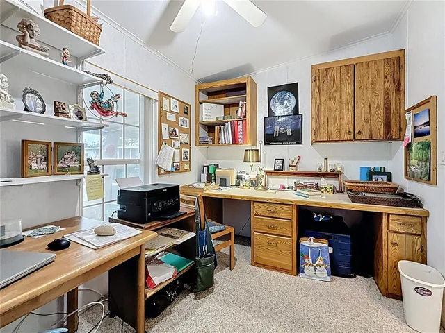a room with a computer on the table and cabinets