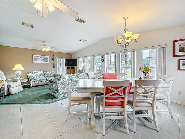 a living room with furniture a chandelier and a dining table