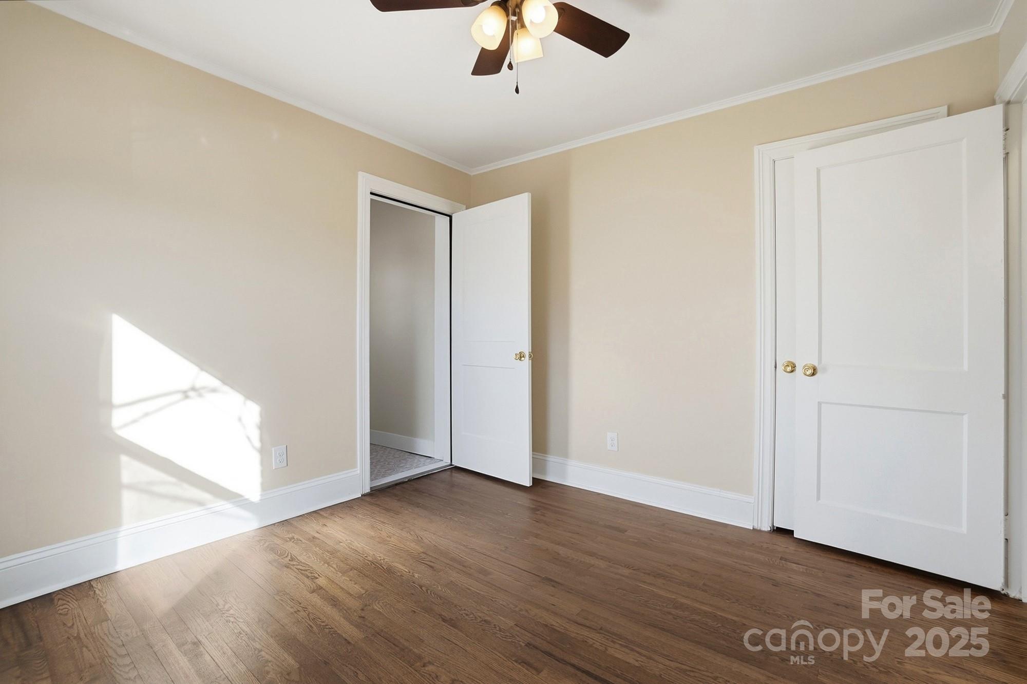 412 Ridge Street Stanley, NC 28164 - Photo 23 of 30 an empty room with wooden floor chandelier fan and windows