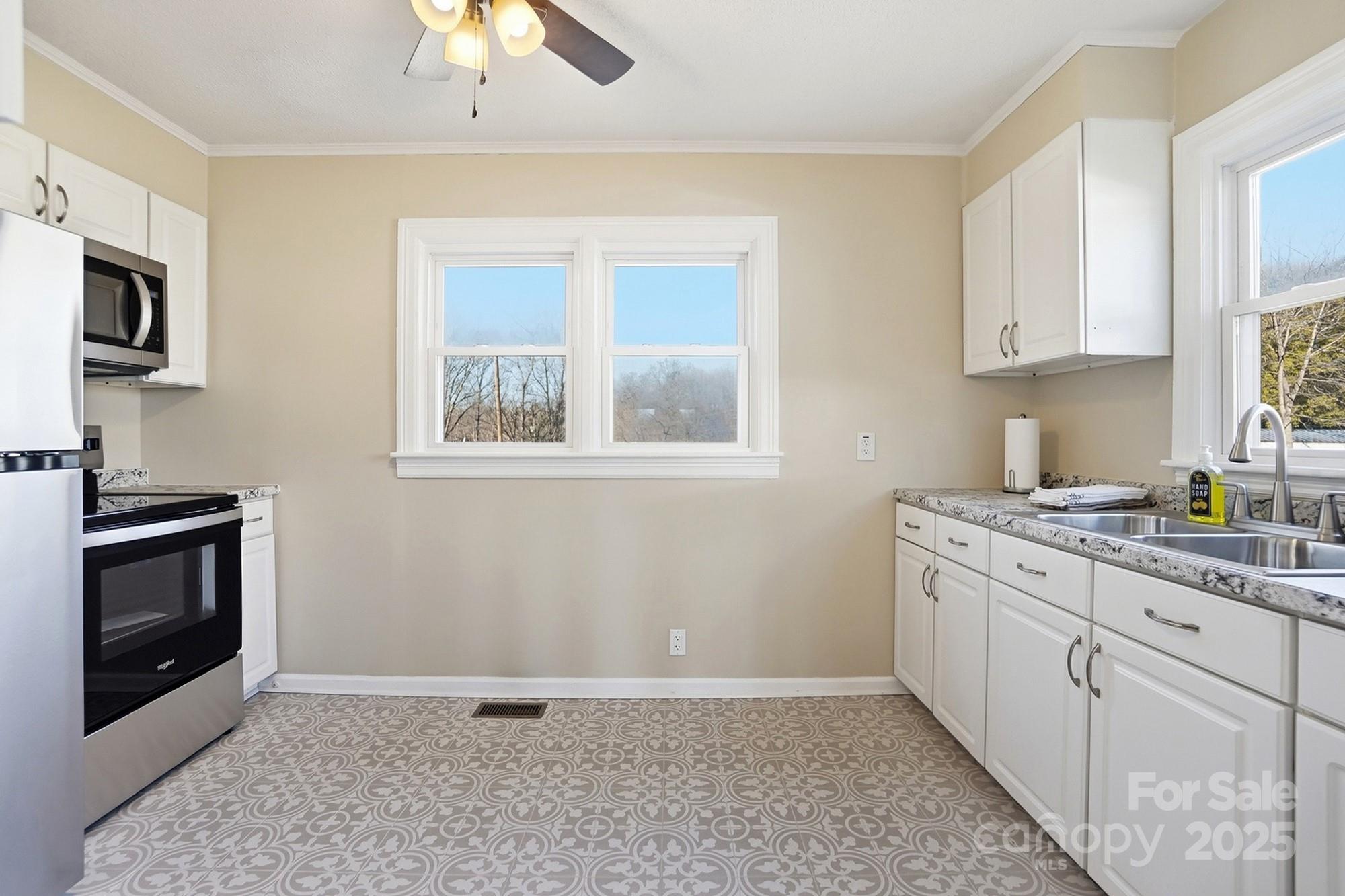 412 Ridge Street Stanley, NC 28164 - Photo 8 of 30 a kitchen with stainless steel appliances granite countertop a stove a sink and a microwave