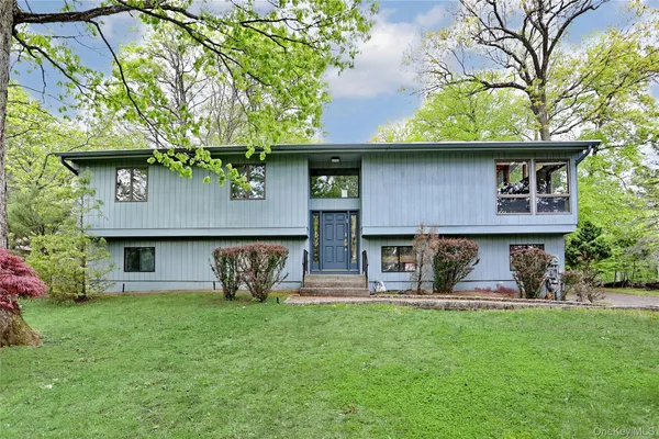 a view of a house with a yard and a large tree