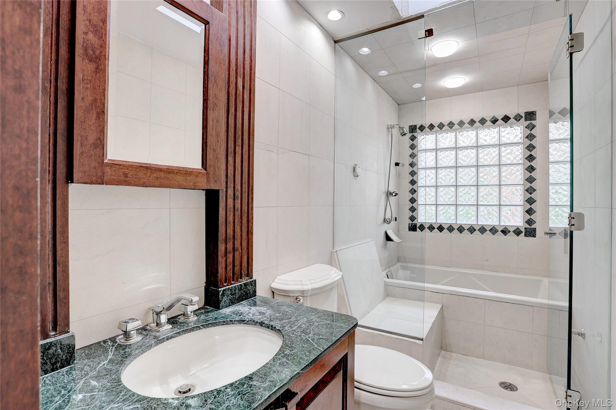 23 Sherwood Ridge Road Pomona, NY 10970 - Photo 18 of 28 a bathroom with a granite countertop sink toilet a mirror and shower