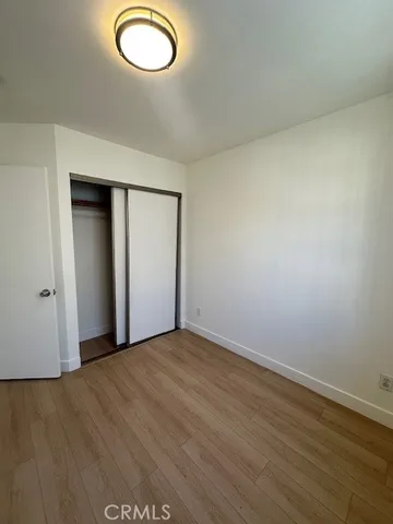 an empty room with wooden floor and mirror